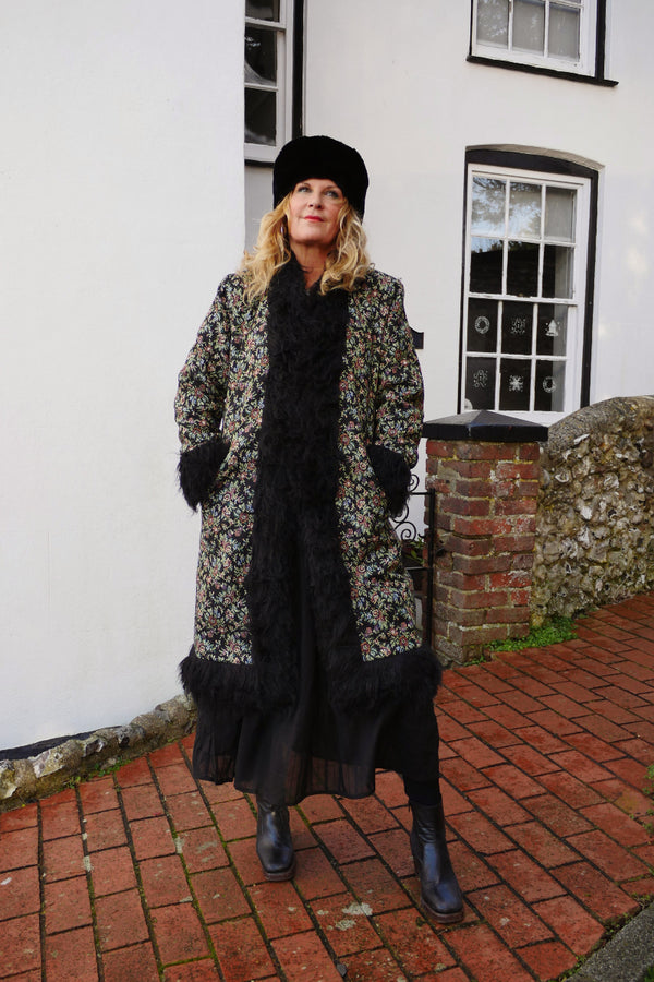 Audrey wears our Fleetwood Coat in Tapestry Black Floral. A 1970s Penny Lane inspired design with fur trim and vintage floral detailing. By All About Audrey