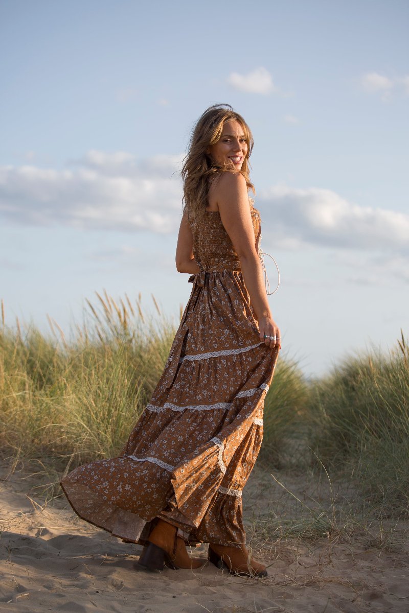 Model wears our Darcy Maxi Dress in Forest Fawn Brown. A beauitful gunne sax inspired design with a velvet fitted laced bodice and flowing tiered cotton skirt of wildflowers. By All About Audrey