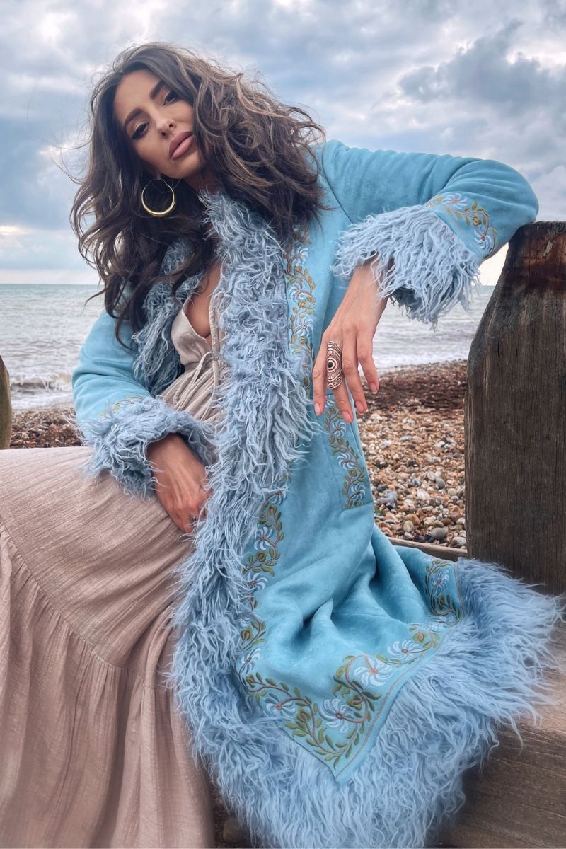 model wears fleetwood penny lane 70s faux suede coat hippy afghan faux fur jacket in baby blue with floral embroidery by all about audrey