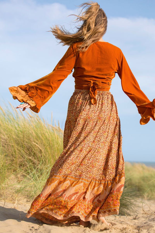 back view on model model wears peacock prairie maxi skirt in tan and turmeric indian style printed sustainable rayon all about audrey