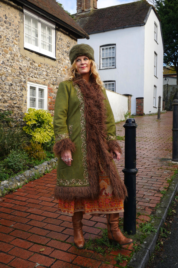 Audrey wears our Fleetwood Embroidered Penny Lane Coat in Rumours Green. A vintage 1970s inspired Afghan design in a warm, light olive tone and honey hue embroidery. By All About Audrey